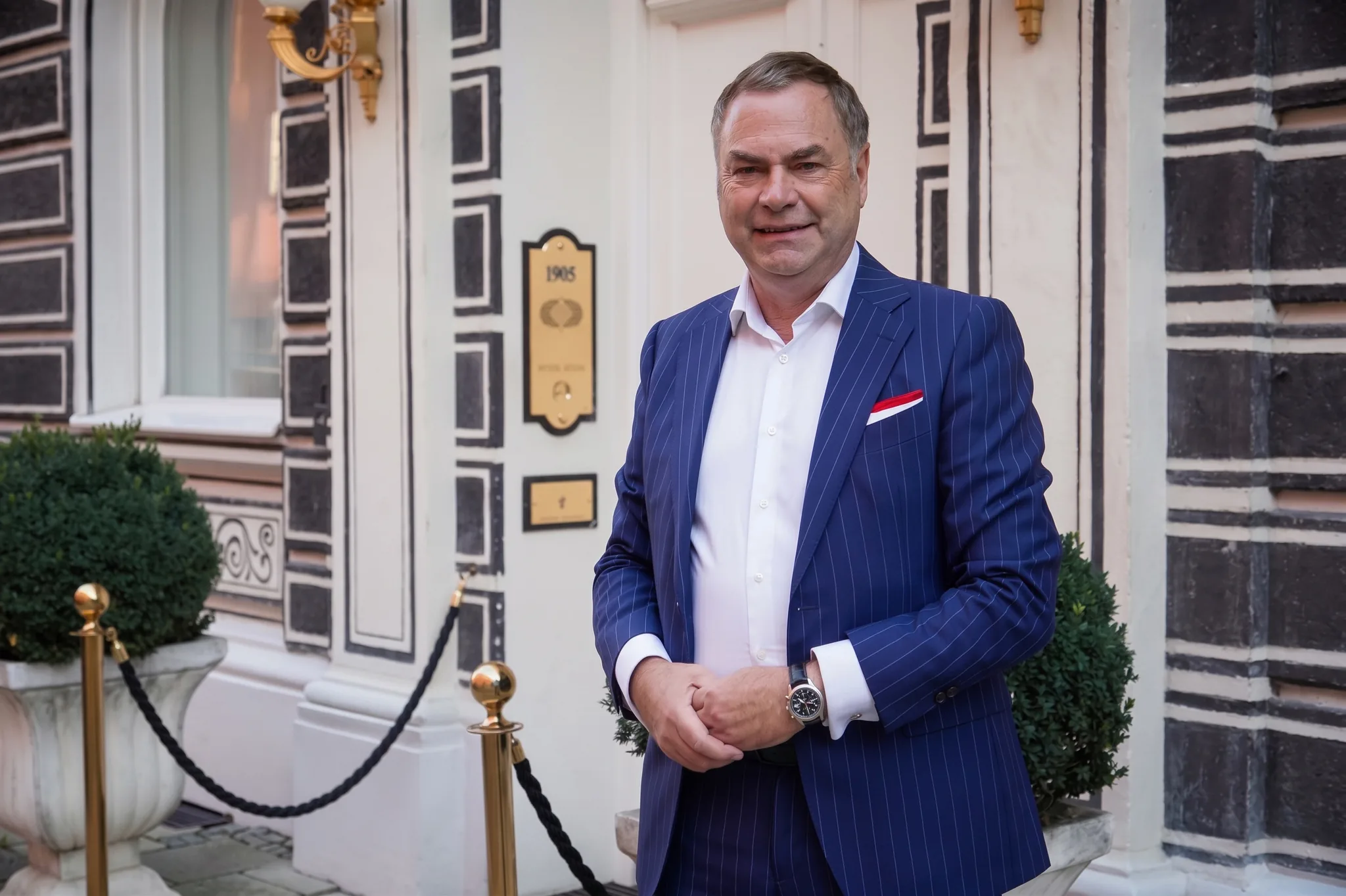 Hermann Wala im blauen Anzug vor einem historischen Gebäude